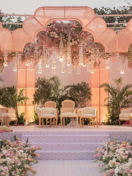 The mandap stage, with its glowing organza arches and ceiling of hanging florals and chandeliers. The design creates a breathtaking focal point for the wedding ceremony.