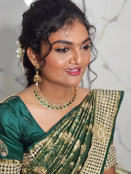 A beautiful look with a green saree and curly hair, perfect for a party or pre-wedding event.