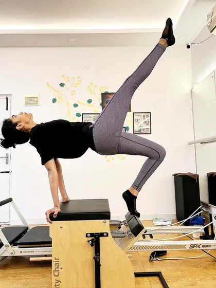 She is happily discovering her own limits. The Wunda Chair is an amazing tool for challenging balance and building integrated body strength, as shown in this elegant pose.