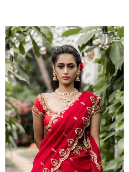 A stunning orange-red brocade lehenga paired with a maroon zardosi embroidered blouse. This ensemble is perfect for a bride seeking a regal and traditional look.