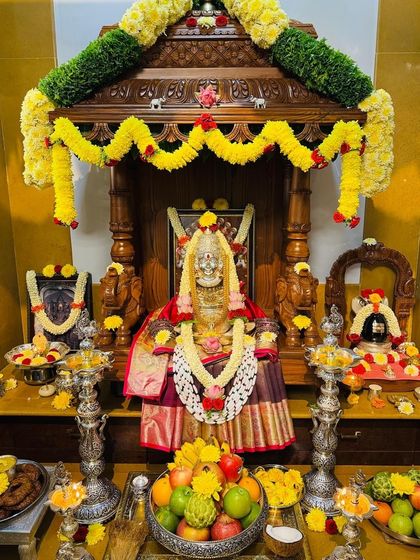 A close-up of the deity during Diwali celebrations, adorned in a rich silk saree and surrounded by offerings.