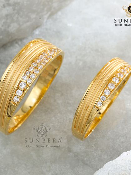 A classic design for the modern couple. These matching gold bands feature a grooved texture complemented by a sparkling row of diamonds, blending traditional craftsmanship with contemporary style.