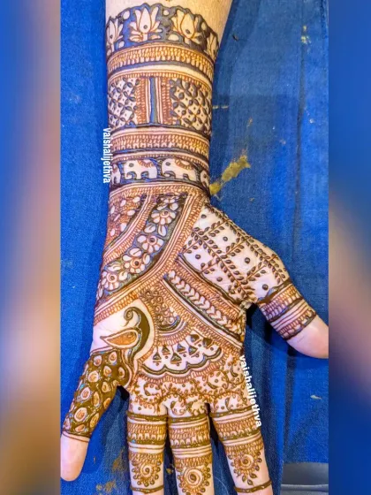 A lovely Indian mehndi design for one hand. It features a peacock, elephant, and lotus motifs, all beautifully arranged in a classic pattern.