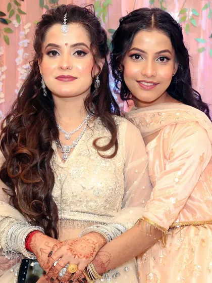 A sweet moment between the bride and her sister, both looking beautiful with their complementary makeup looks.