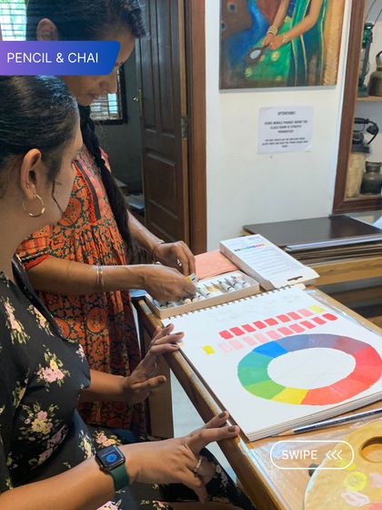 Understanding color is fundamental. Here, I explain the color wheel to a student, a crucial lesson in our foundation courses that underpins all future painting work.