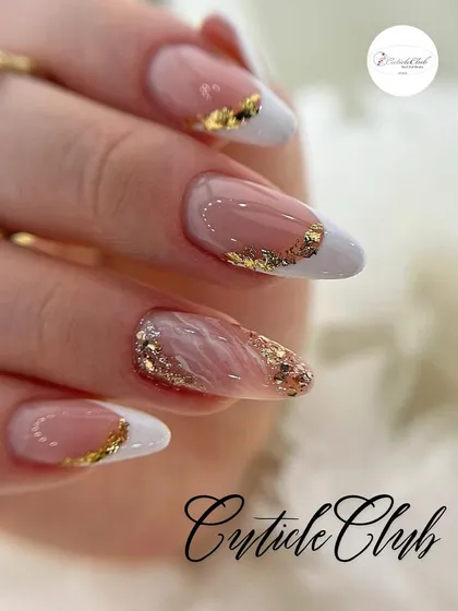 A modern twist on a classic, this design combines a white French tip with delicate gold foil accents. The gold leaf is applied along the smile line and on an accent nail for a touch of sophisticated glamour.