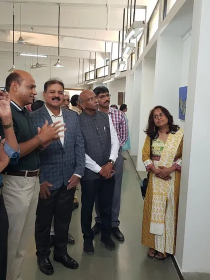 Explaining my artwork to the Hon. Dr. B. G. Shekhar, Special Inspector General of Police, during the Janasthan Group's art exhibition.