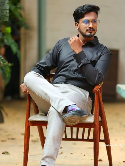 A seated portrait of a male model. The focus is on a sharp, clean look that is perfect for professional headshots or commercial work.