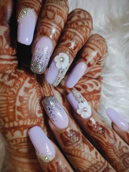 A close-up of a lavender and silver glitter bridal nail set, showcasing the intricate 3D flower and rhinestone details.