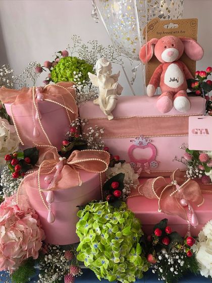 A close-up of the pink floral hamper, showing the mix of flowers and gift boxes.