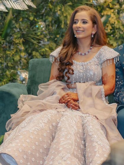 A candid moment of Surbhi at her sangeet. Her soft glam makeup looks radiant and natural, even while seated and enjoying the festivities.