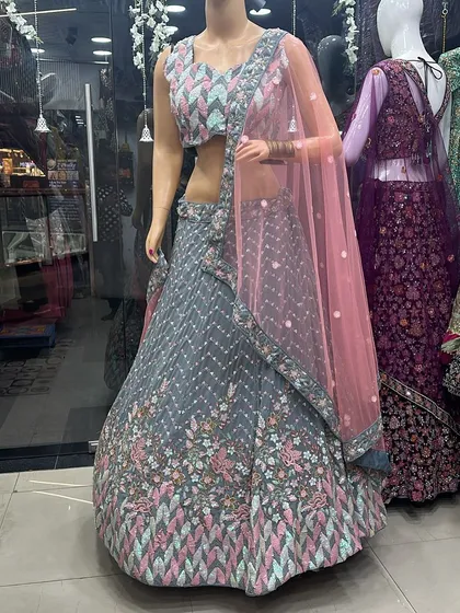 A grey lehenga with a geometric sequin blouse on a mannequin, showcasing a modern and chic design available in our store.