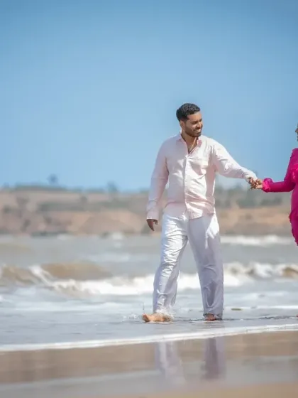 A beautiful, wide shot of a couple walking hand-in-hand on the beach during their pre-wedding shoot. This image captures the feeling of starting a new journey together.