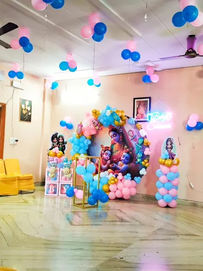 A wide shot of the Kanha ji baby shower decorations, showing how the entire room is brought to life with balloons on the ceiling and the main backdrop.