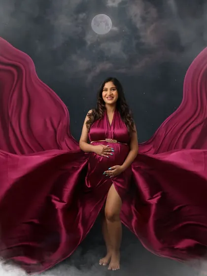 A celestial dream. This mom-to-be stands under a full moon, wrapped in a magnificent magenta gown that seems to blend with the clouds.