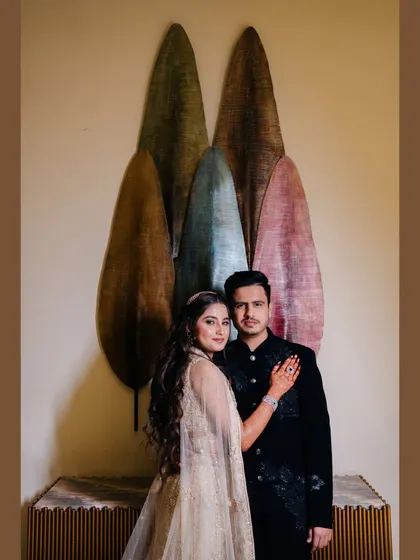A stylish portrait of the couple at their reception. Their coordinated outfits and confident poses make for a very fashionable shot.