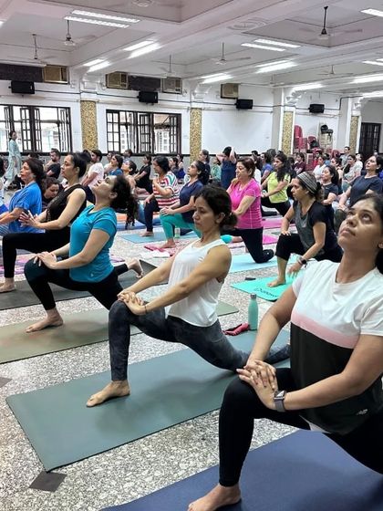 Our community practicing Anjaneyasana (Low Lunge) together during our International Yoga Day event. This pose is excellent for stretching the hips and quadriceps.