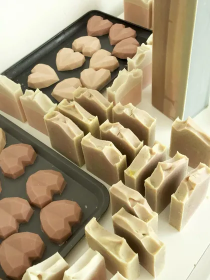 Heart-shaped soaps and freshly cut bars waiting to be stamped.