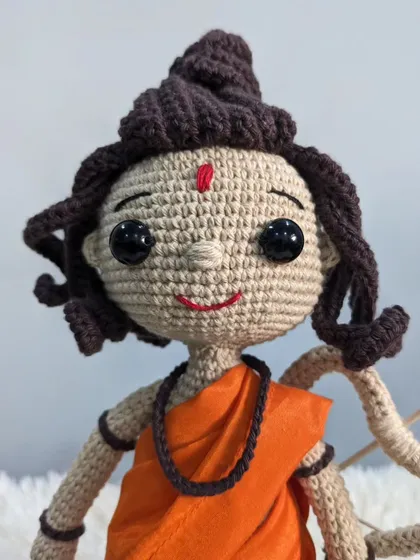 A close-up of the Shree Ram doll's gentle and smiling face.