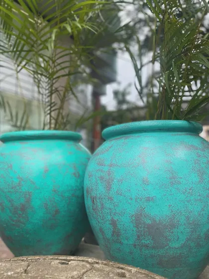 A pair of my antique-finish teal planters, perfect for adding a vibrant splash of color to your garden.