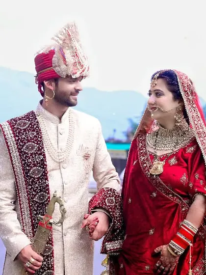 A beautiful shot of a newly married couple against a mountain backdrop. This image captures the beginning of their journey together in a stunning Himachali setting.