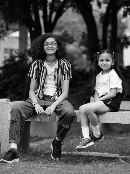 A posed black and white portrait of two sisters. This classic style highlights their features and the quiet confidence in their poses.