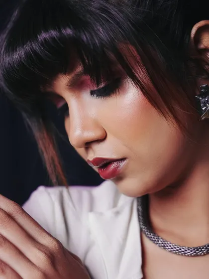 A delicate, soft-focus portrait. This pose highlights the makeup and the intricate details of the model's expression.