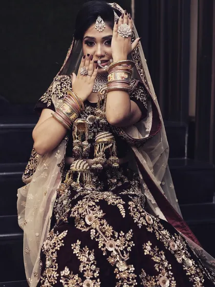 A shy and playful pose from a bride in a deep maroon lehenga. The vintage processing gives this photo a timeless quality.