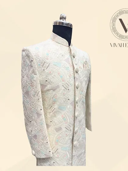 Here is my classic ivory sherwani, a perfect choice for the groom. This piece features delicate, tone-on-tone embroidery with subtle pastel highlights, giving it an elegant and sophisticated look. It’s a timeless outfit for your big day.