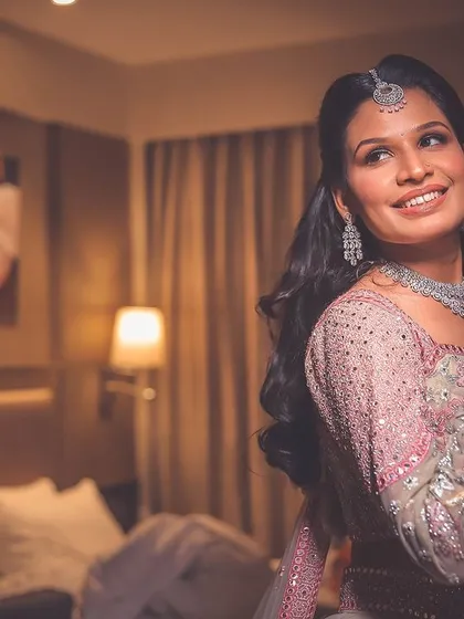 A portrait of a guest or bride getting ready, capturing a happy, relaxed moment in a hotel room setting.