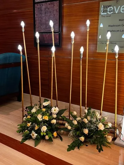A close-up of the modern, candle-like floor lamps used to create a warm and inviting pathway.