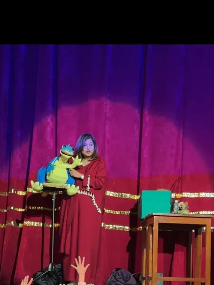 Dennis Saur the dinosaur puppet interacting with the kids. The puppets help create a playful and engaging experience.