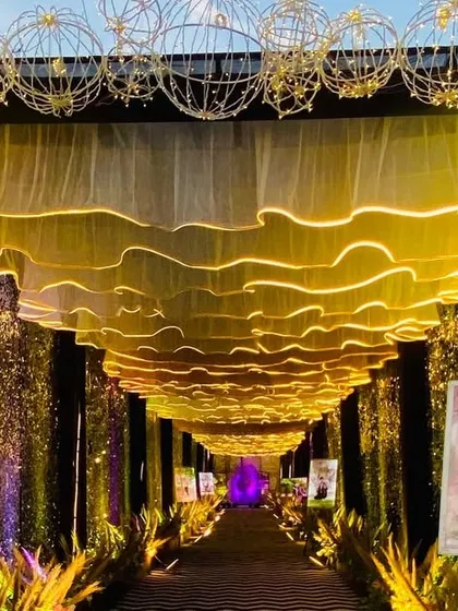 A closer look at the modern sequin and gold entrance, showing the details of the illuminated wavy ceiling and the custom photo displays.