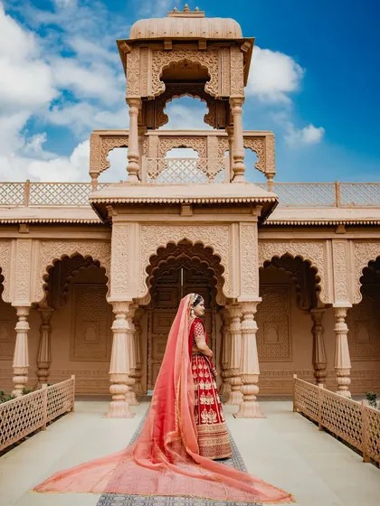 A breathtaking bridal portrait with a long, flowing veil against a magnificent architectural backdrop. This shot is the epitome of royal elegance and grandeur.