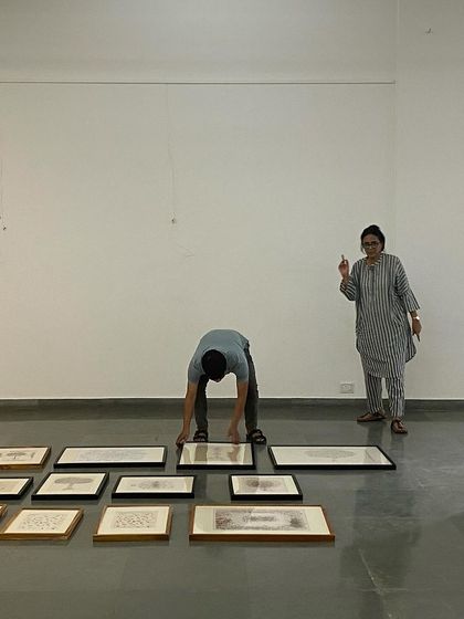 Curator Pushpamala N directing the installation of 'Hand Prints'.
