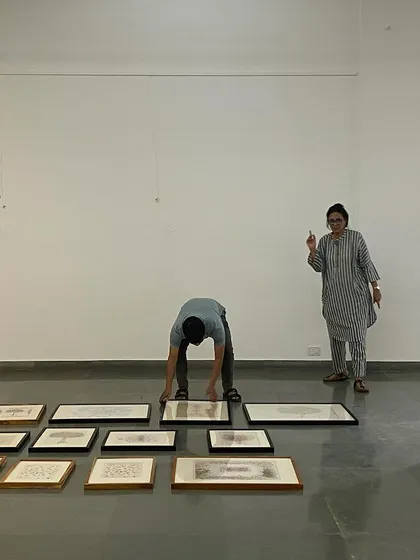 Curator Pushpamala N directing the installation of 'Hand Prints'.