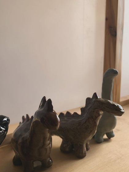 A close-up of the dinosaur sculptures, showing the texture of the glaze.