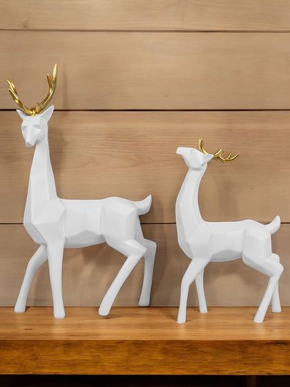 A pair of modern, geometric deer showpieces in clean white with golden antlers. Their minimalist design makes them a perfect addition to a contemporary or Scandinavian-style interior.