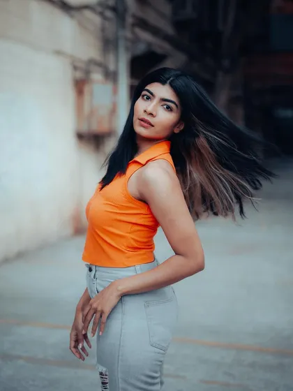 A dynamic shot of a model with her hair in motion, captured in an urban alley. This adds a sense of energy and life to the portrait series.