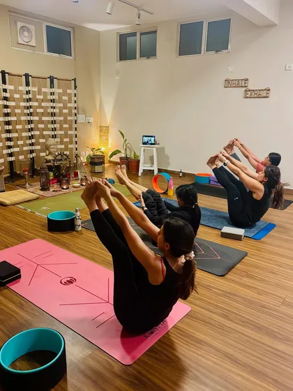 Students holding Navasana (Boat Pose), a powerful core-strengthening posture. A strong core is the foundation for almost every other asana in yoga.