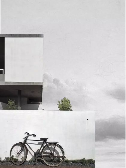 A stylized, artistic photograph of the Aayi House, emphasizing its strong geometric forms and minimalist aesthetic. The image captures the quiet poetry of the architecture.