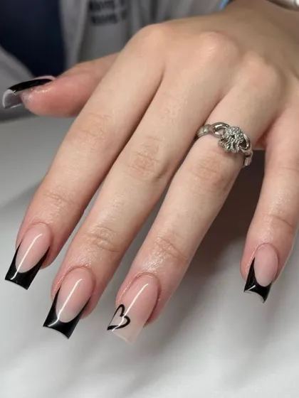 A modern black French manicure on square nails, with one accent nail featuring a simple heart outline.