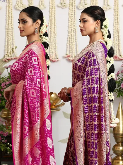 A side profile of the two models, showcasing the rich texture and drape of the Bandhani silk sarees.