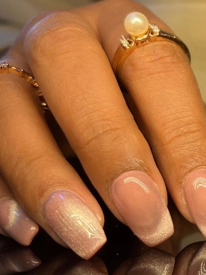 A beautiful cat-eye manicure with a soft white shimmer over a nude base, giving a clean and polished look.