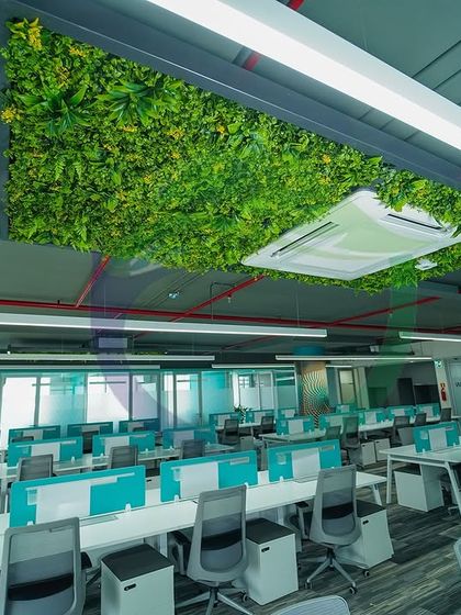 In this large open-plan office, we installed a green ceiling panel above the workstations. This not only adds a splash of nature but also helps with acoustics, absorbing sound in a busy environment.