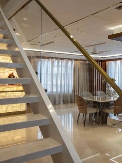 The custom-designed staircase with a backlit onyx wall, serving as both a functional element and a stunning light sculpture.