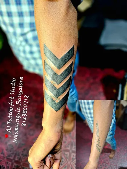 This image shows a before and after of a forearm cover-up. I completely hid an old script tattoo with a bold, geometric chevron band, demonstrating how a new design can effectively replace unwanted ink.