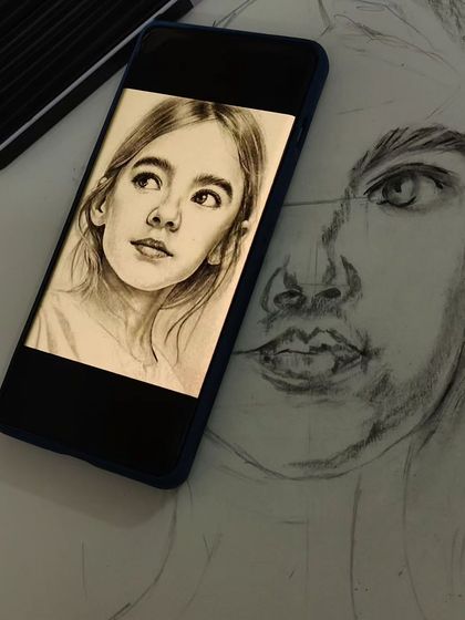 We teach modern techniques, including how to effectively use digital references. Here, a student works on a portrait sketch, using a smartphone display to guide their proportions and shading.