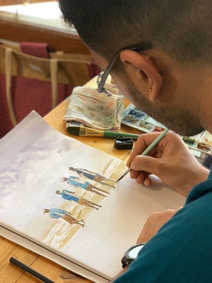 A student paints a scene of figures on a beach. Our courses cover a wide range of subjects, including figurative work, to build versatile skills.