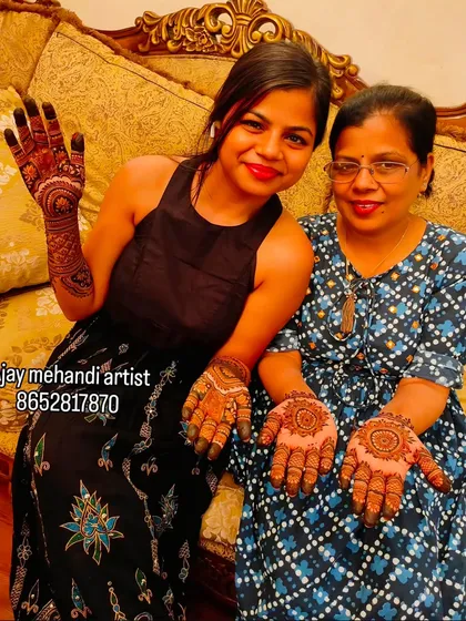 Happy clients are our best advertisement. We love when guests proudly show off their finished henna designs, one with a full-hand traditional pattern and the other with a classic mandala.